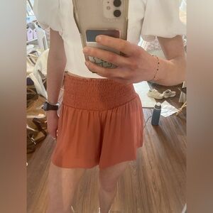 The impeccable pink orange smocked skort